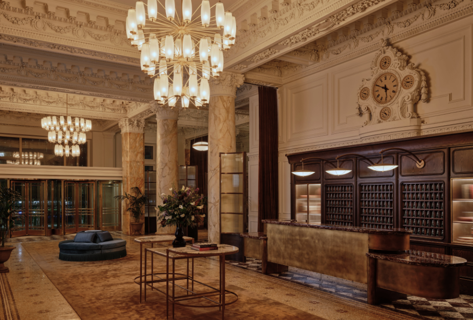 a lobby with a large chandelier and a clock