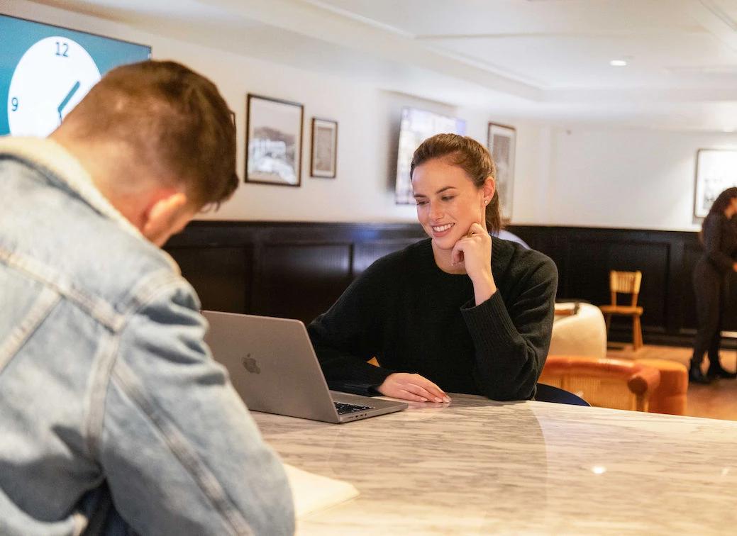a woman sitting at a table with a laptop