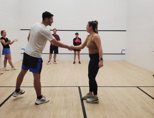 a man and woman shaking hands in a gym