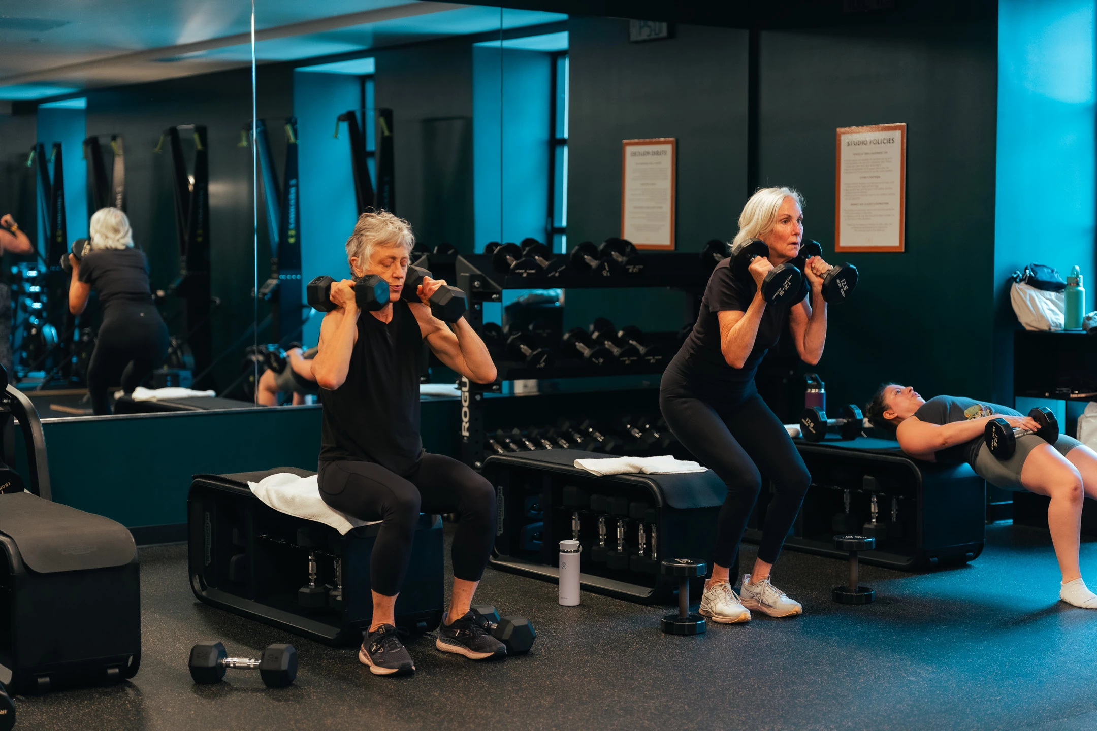 a group of people lifting weights in a gym
