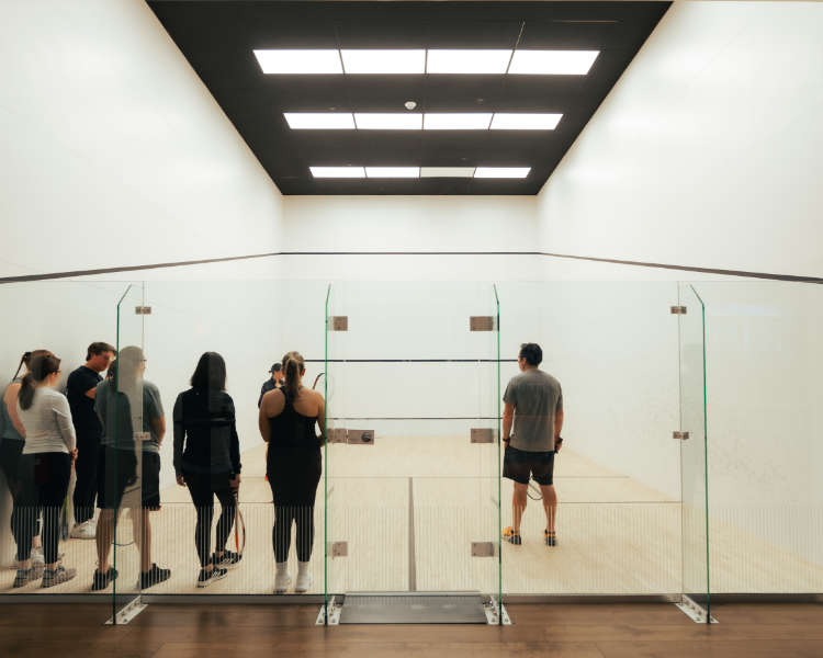 a group of people standing in a room with glass walls