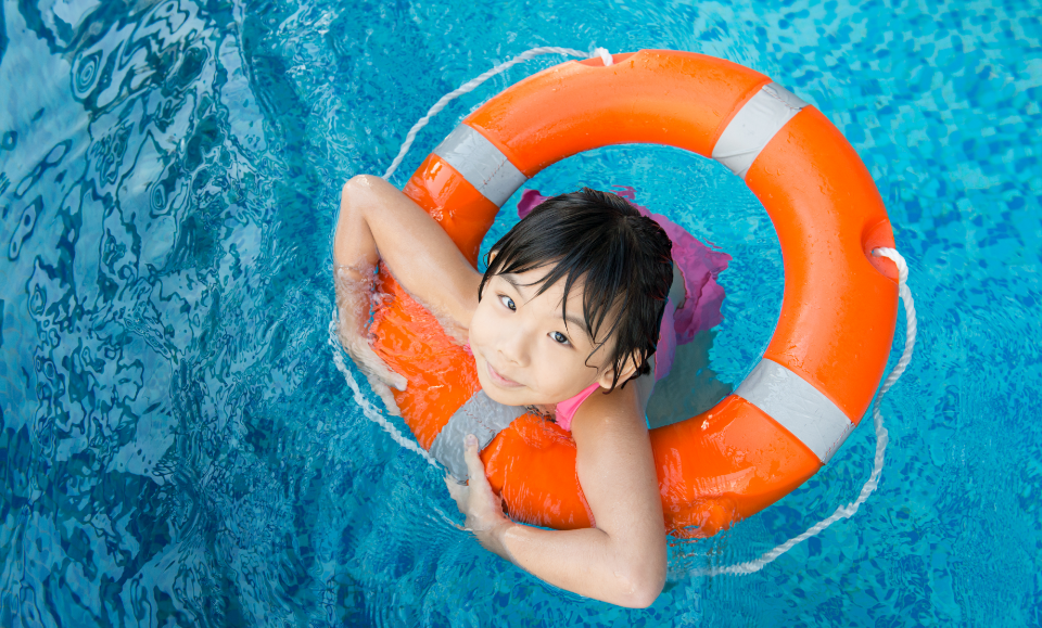 a child in a pool with an orange and grey float tube
