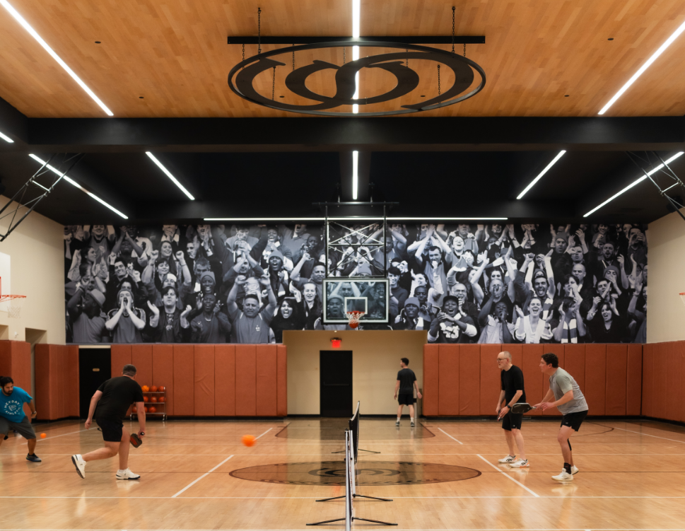 a group of people playing tennis in a gym