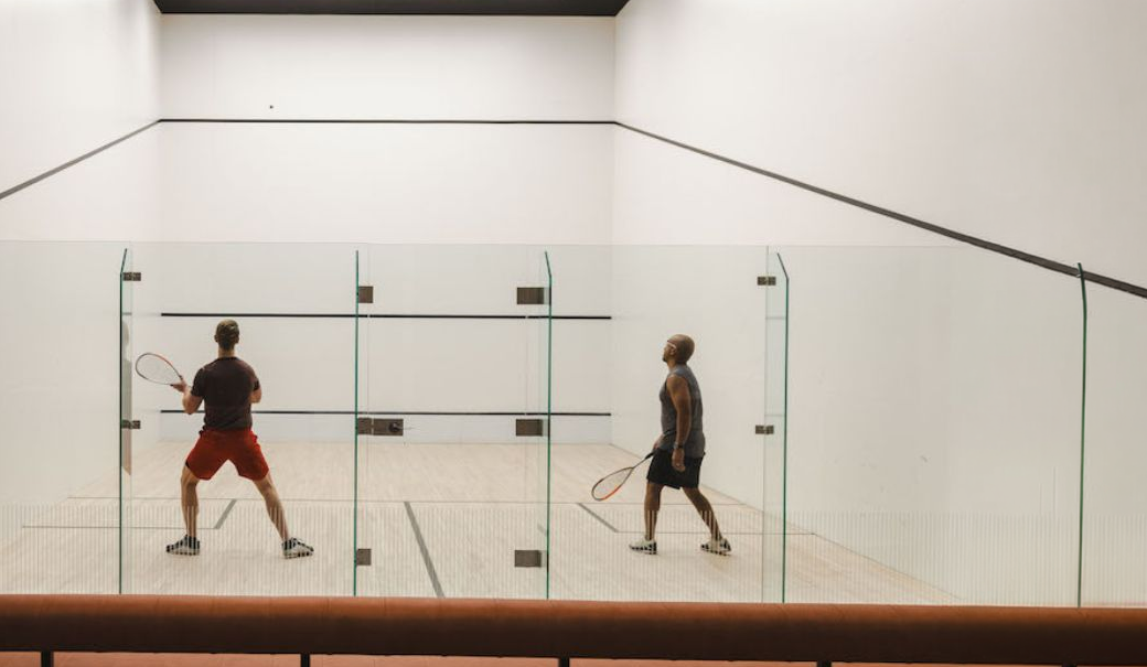 two men playing squash in a room