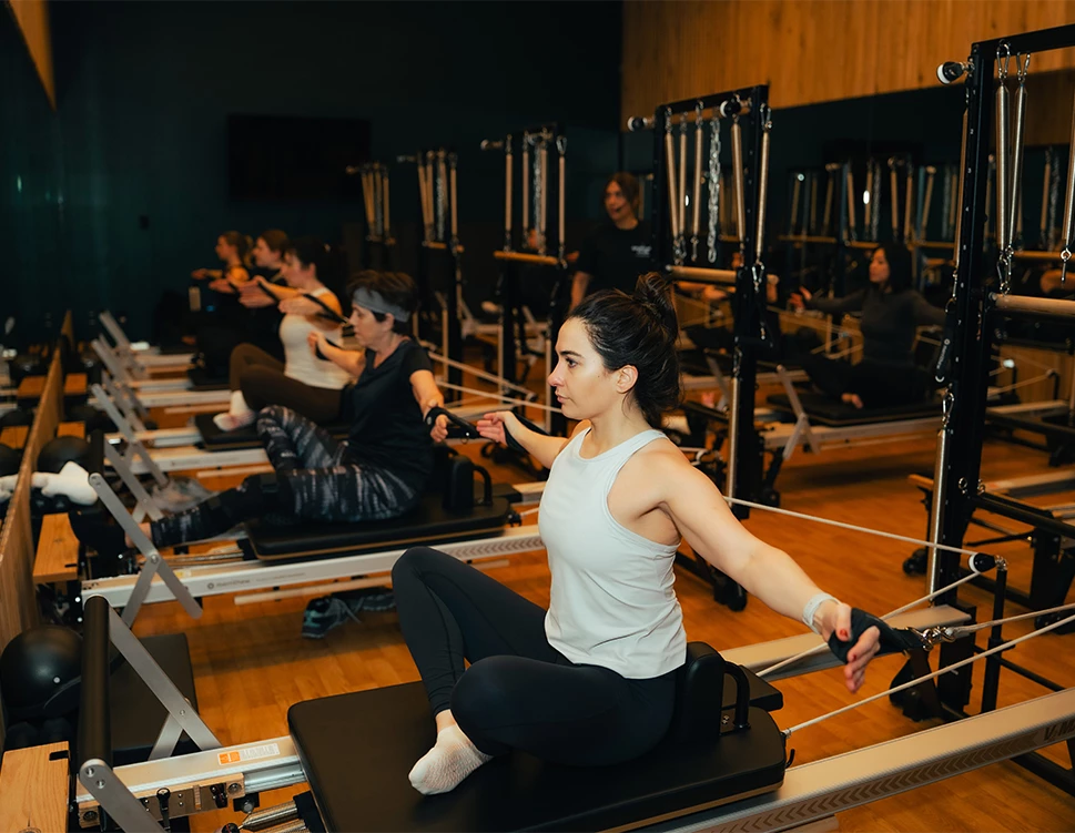 a group of people on a reformer