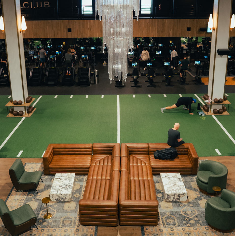 a man sitting on a couch in a large room with people in the background