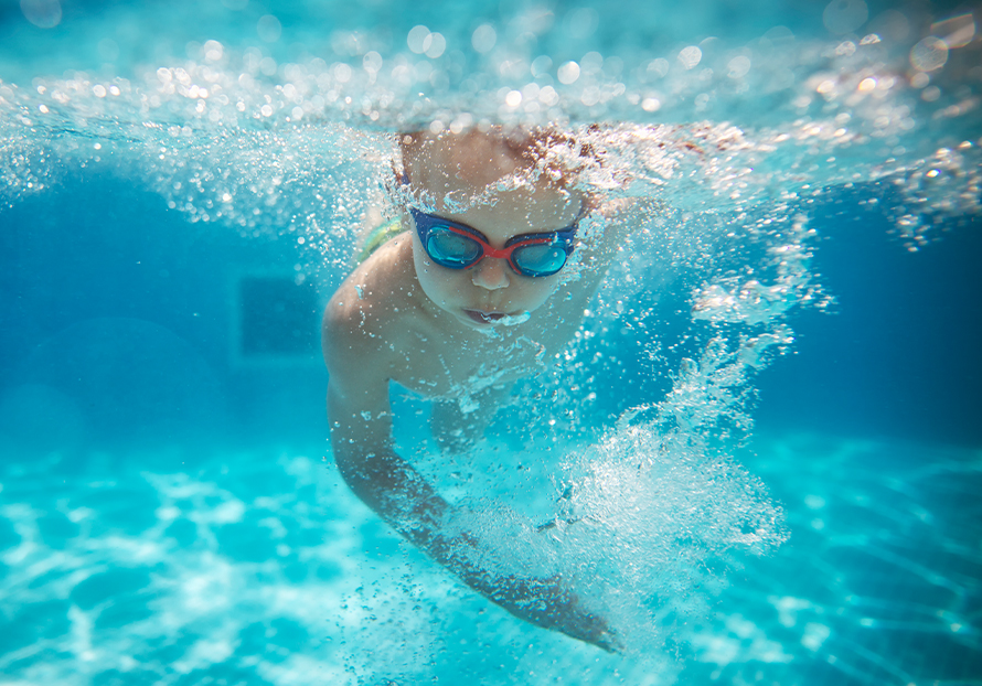 a child swimming underwater with goggles
