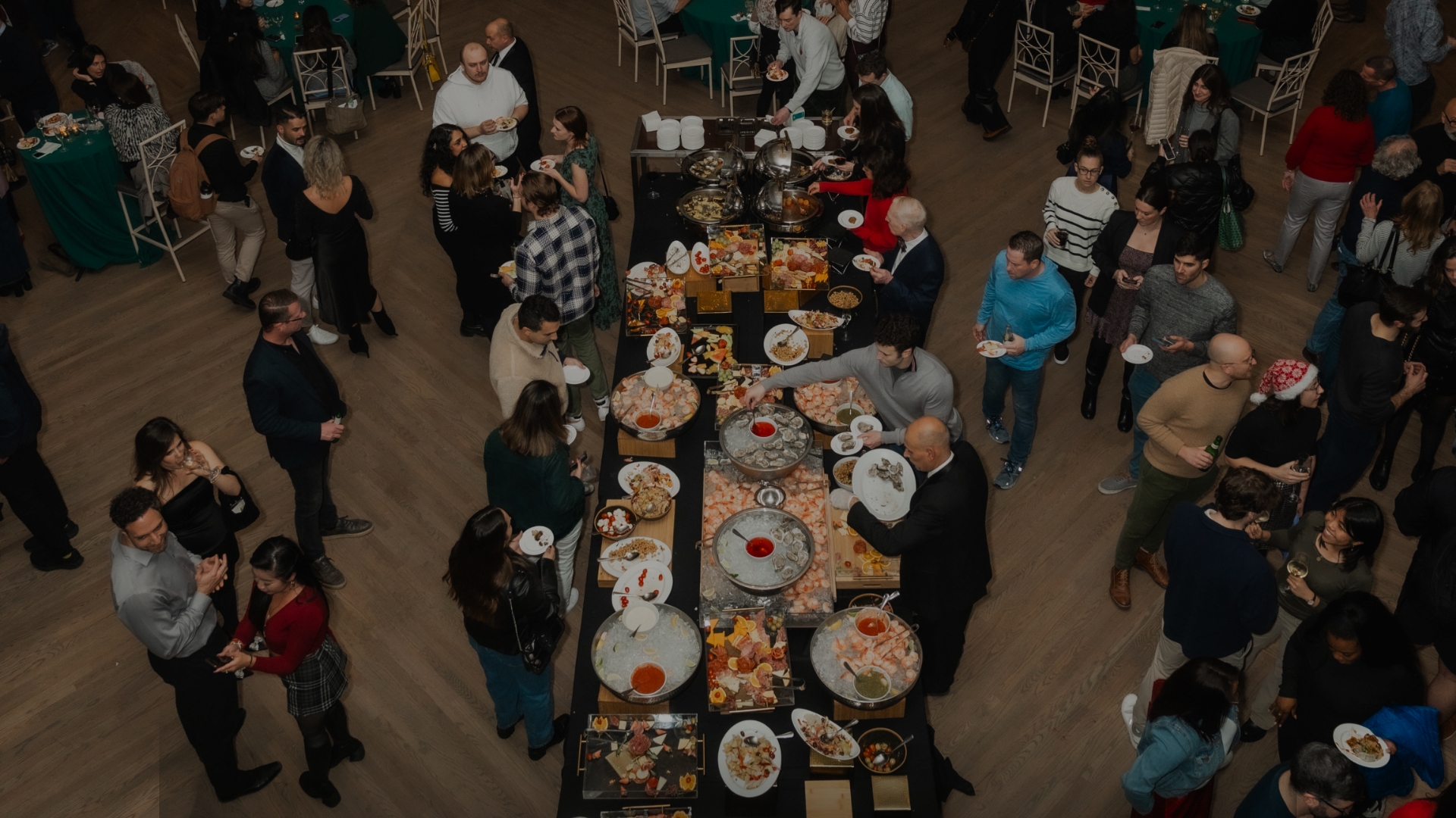 a group of people standing around a table full of food