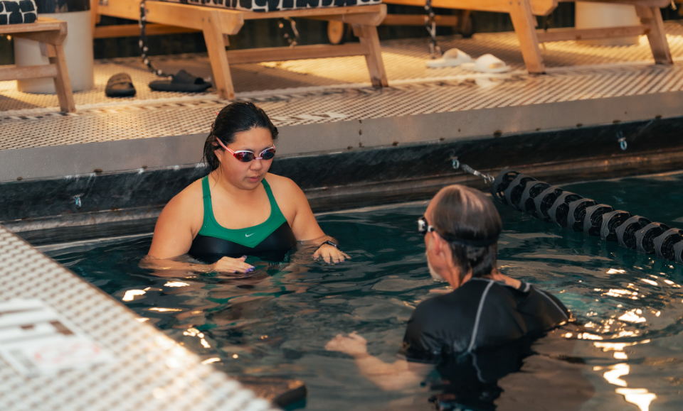 a woman in a pool with a man in a swimsuit