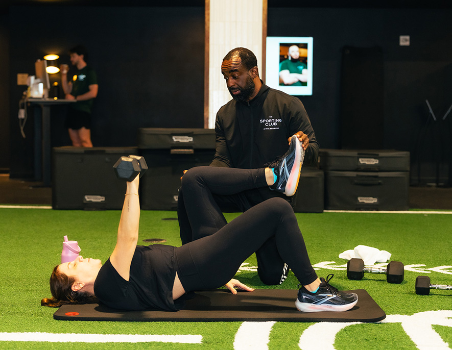 a man helping a woman do a workout