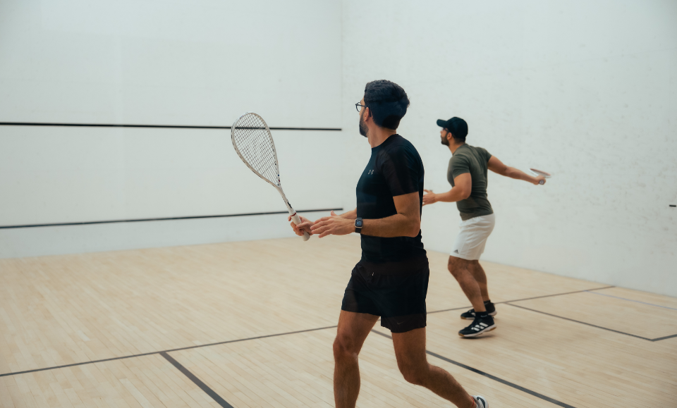 a man holding a racket in a squash court