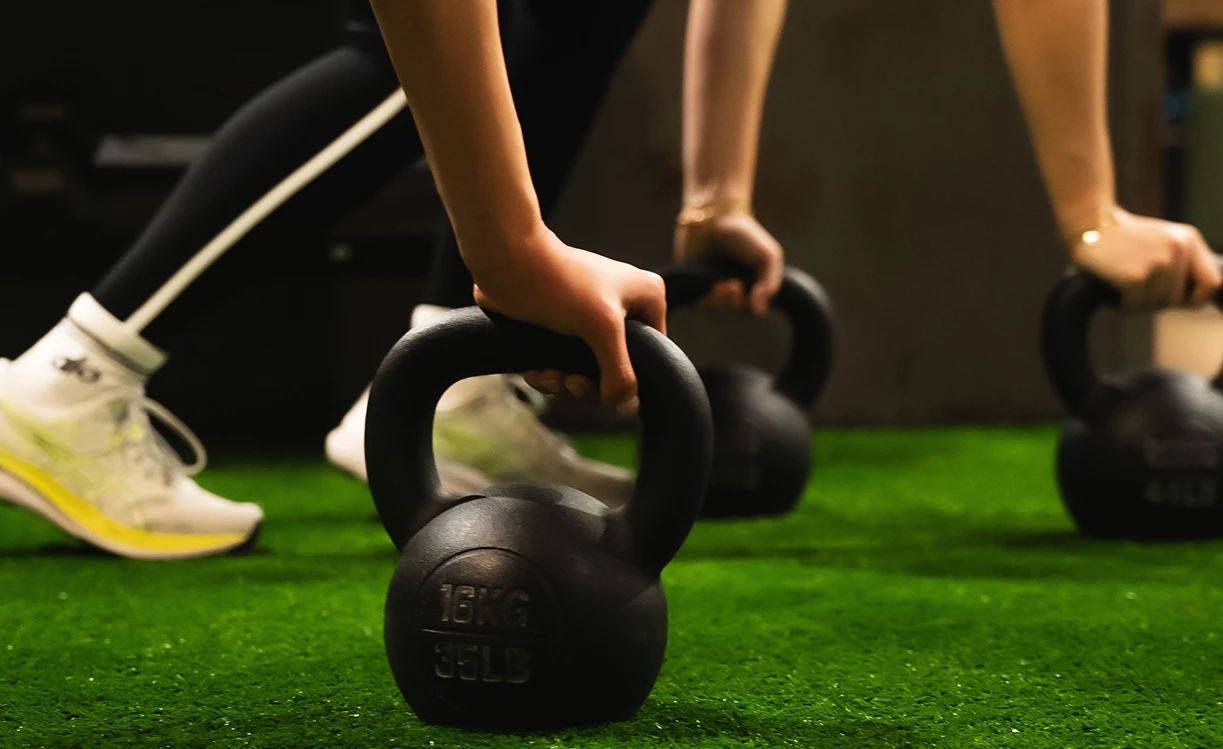 a person lifting weights on a green surface