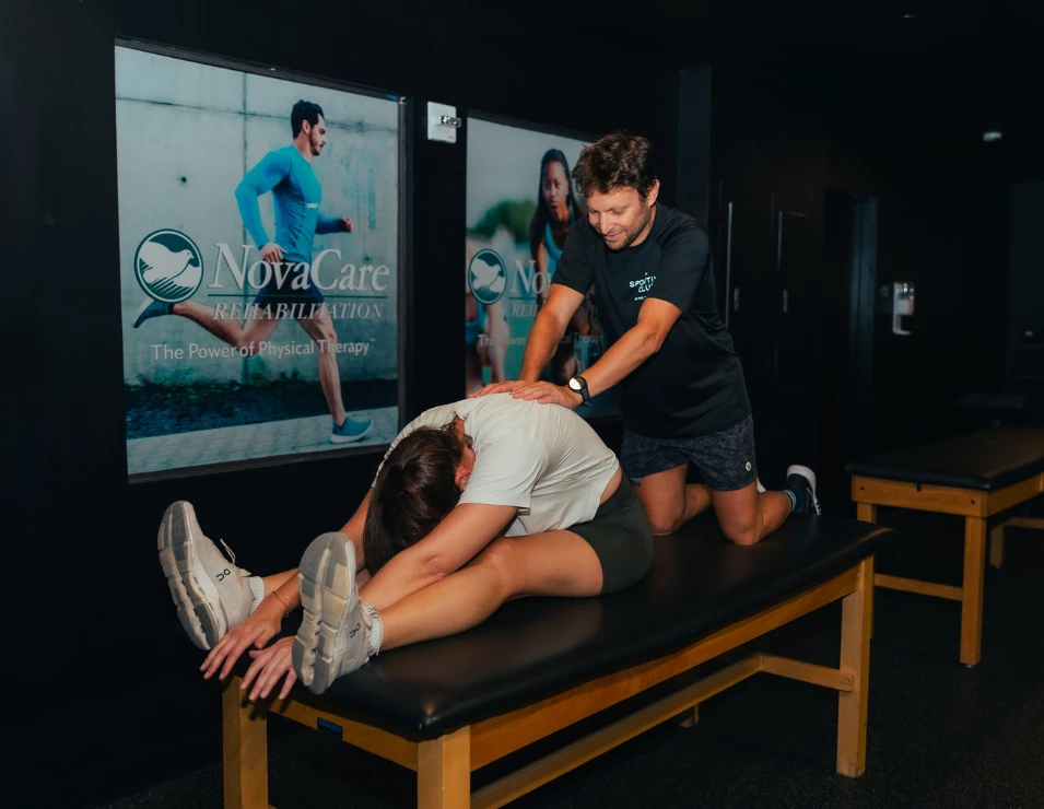 a man stretching a woman on a bed