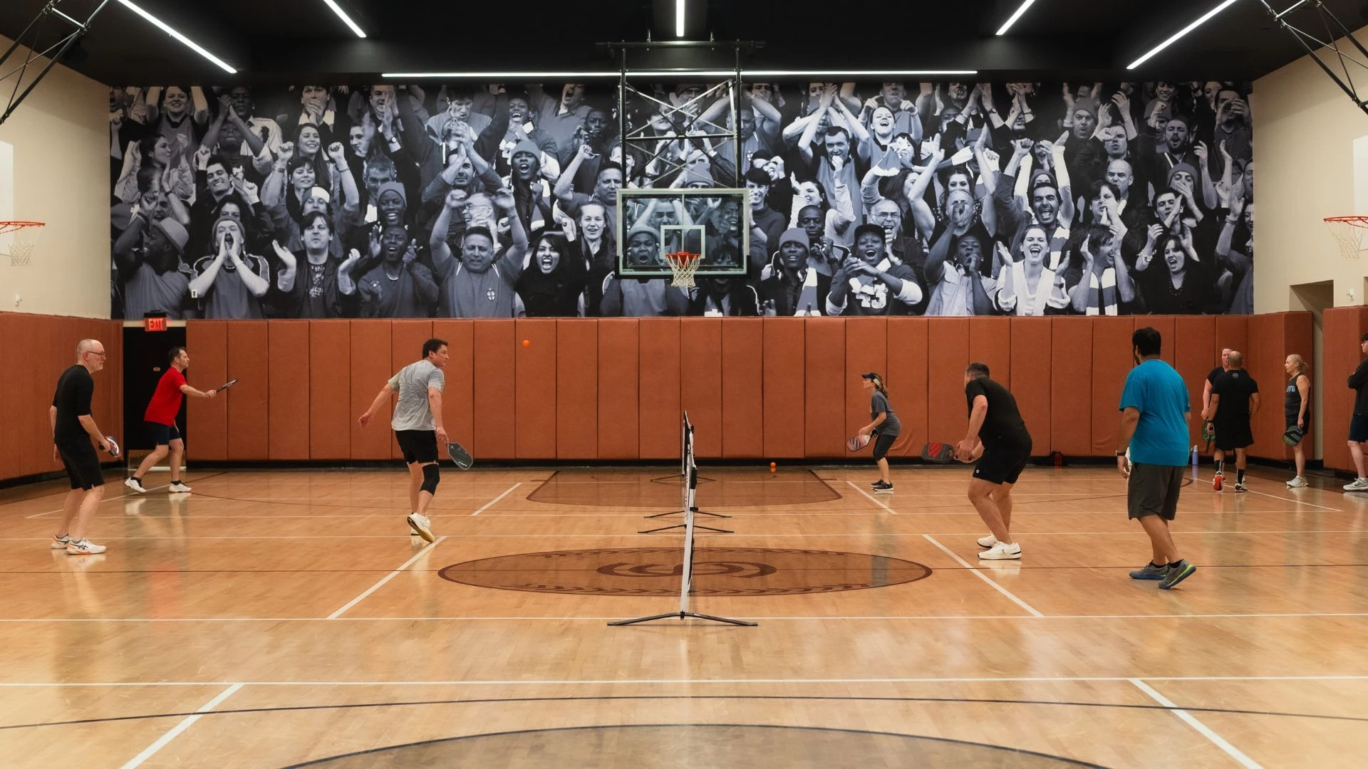 a group of people playing basketball in a gym
