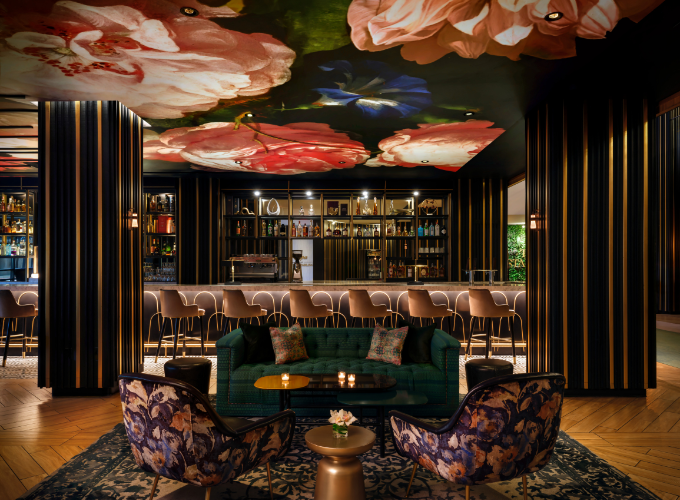 a room with a bar and a green couch and chairs