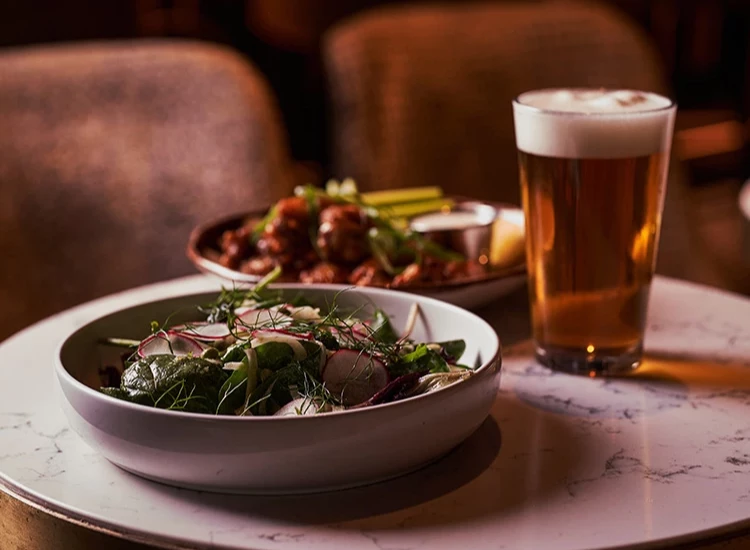 a bowl of salad and a glass of beer