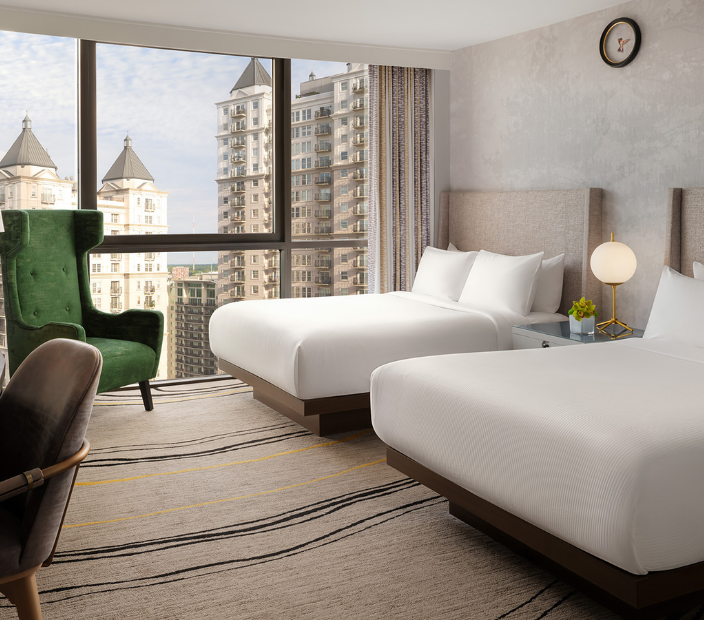 a room with two beds and a green chair