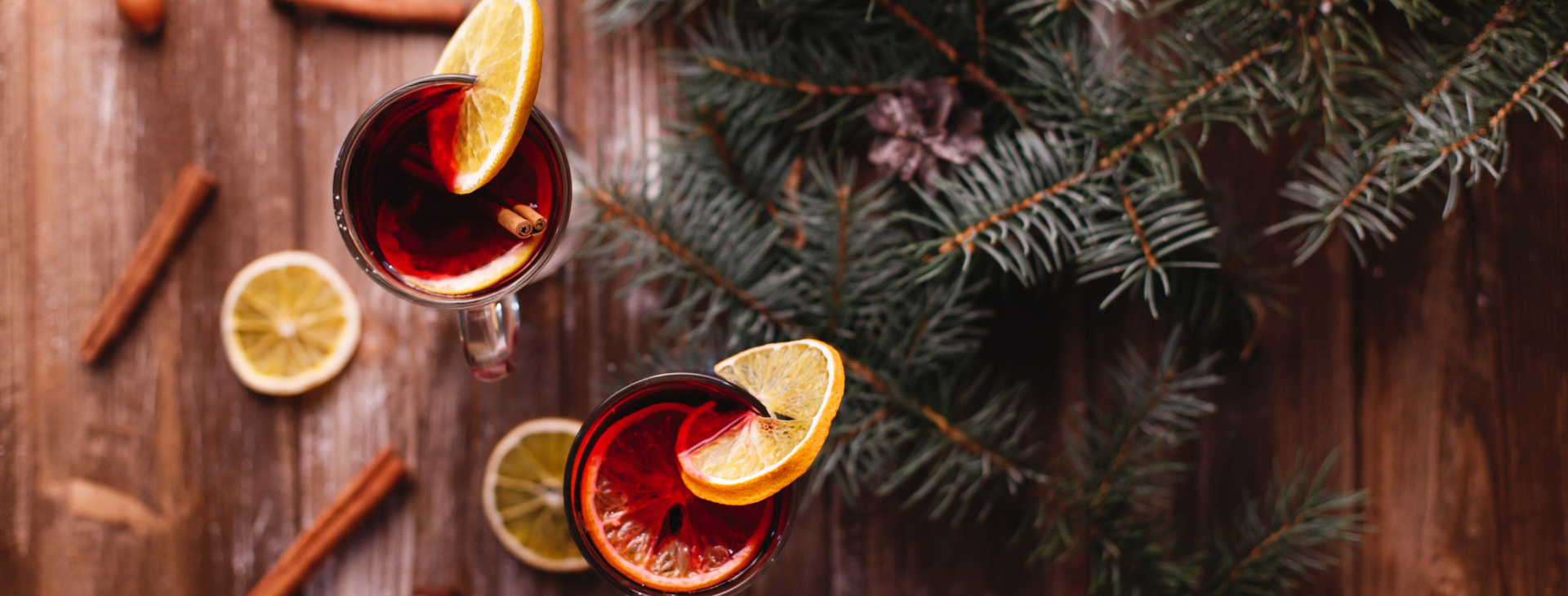 a glass of mulled wine with fruit slices and cinnamon sticks