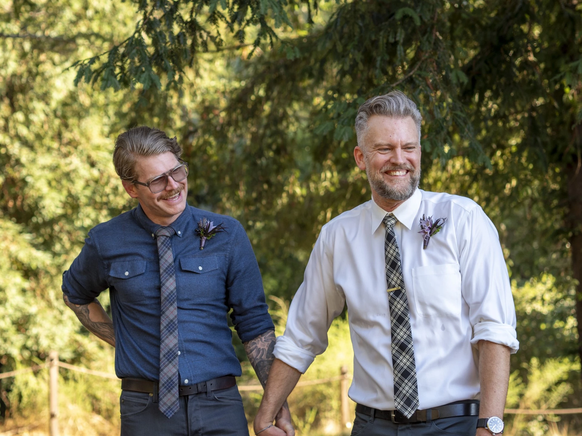two men holding hands and smiling