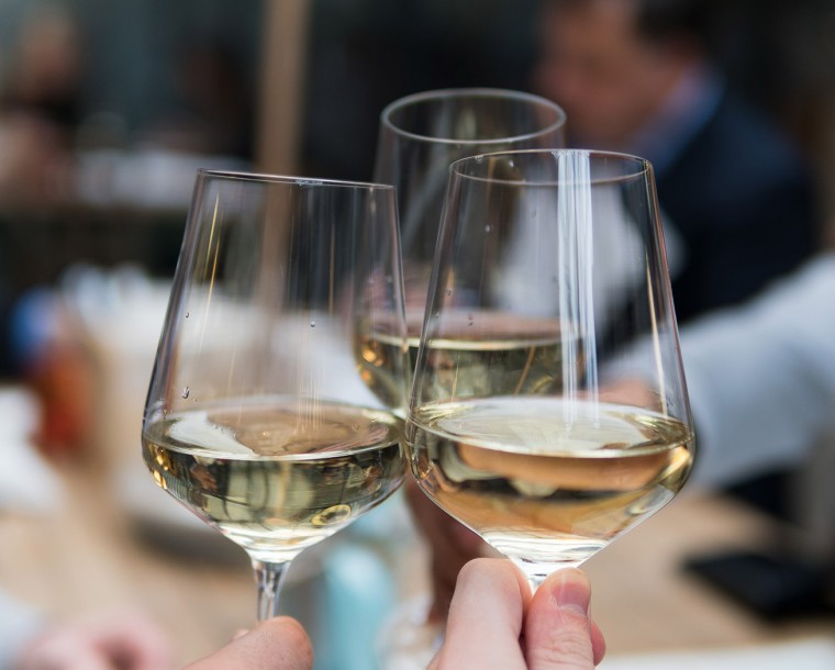 people toasting three glasses of white wine