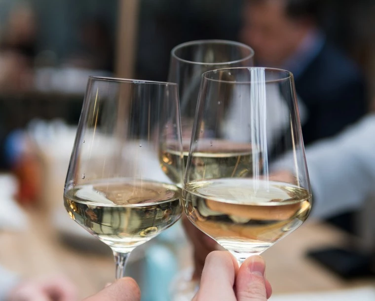 people toasting three glasses of white wine