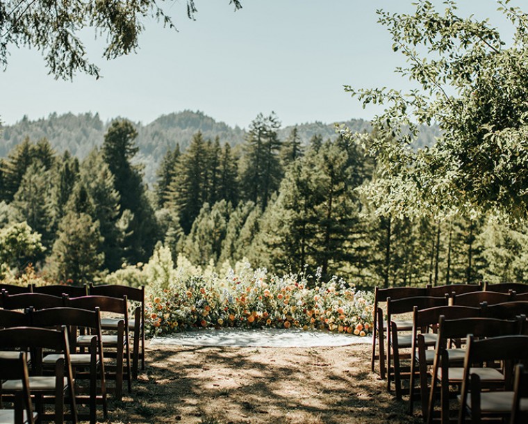 wedding ceremony with chairs on both sides and floral arrangement at the front