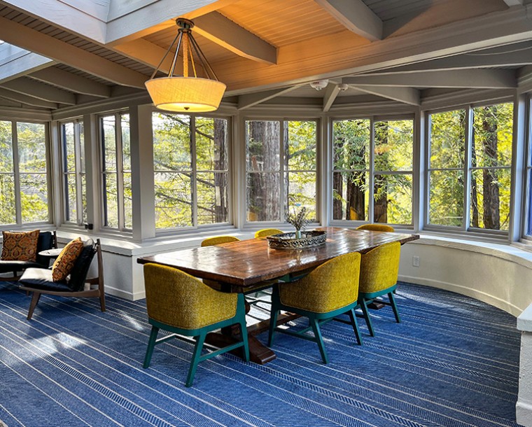 windows all around the room with table and chairs