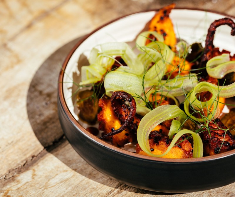 octopus dish with green garnishing in a bowl