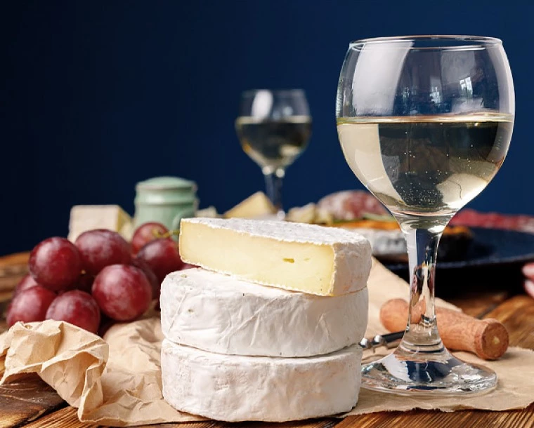 white wine and cheese on a wooden board