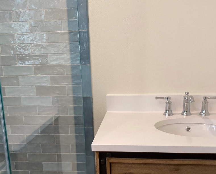 bathroom sink with light blue and grey tiles