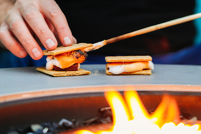 guy doing a smores by bonfire