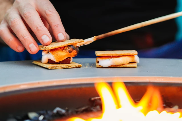 guy doing a smores by bonfire