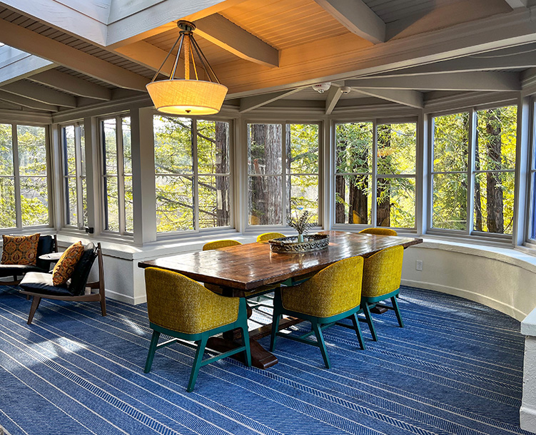 windows all around the room with table and chairs 