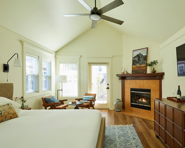  armstrong guestroom with fireplace, bed, chairs and door to outside