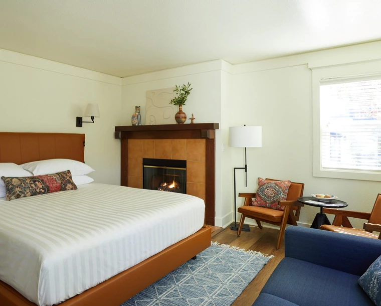 armstrong guestroom with bed chairs fireplace and blue couch