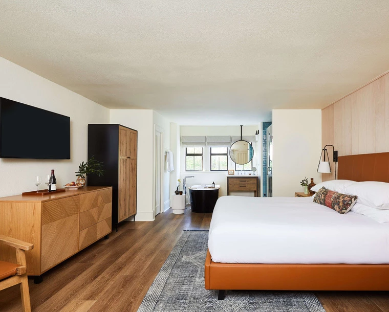 cazadero guestroom with tv on wall and bed with white sheets
