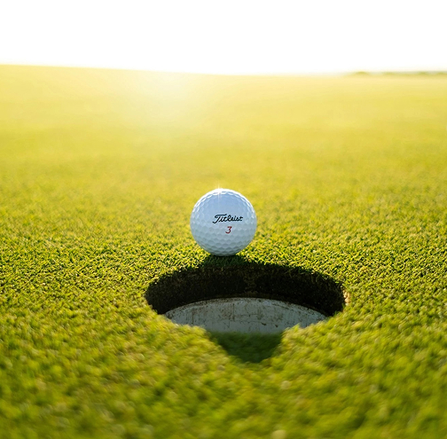 a golf ball on the edge of a hole
