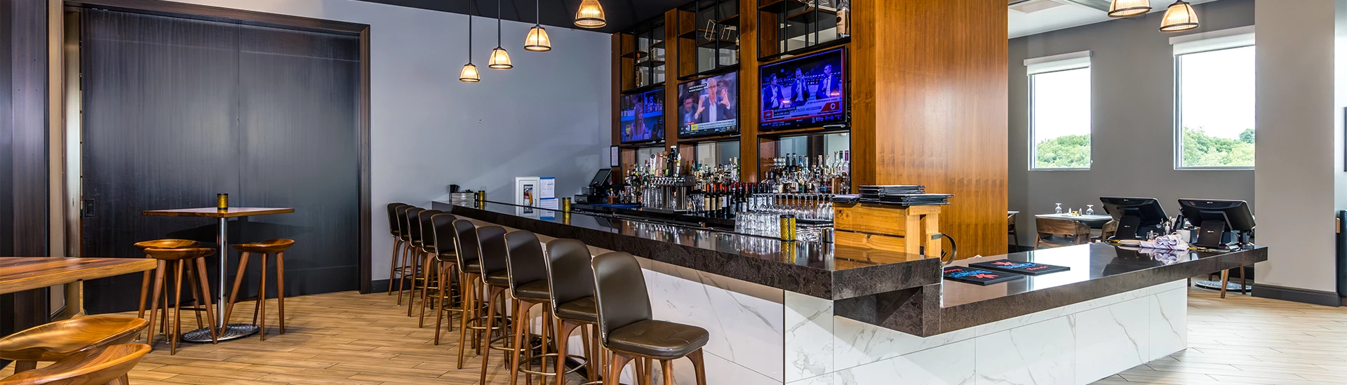 a bar with a row of chairs and a television on the wall