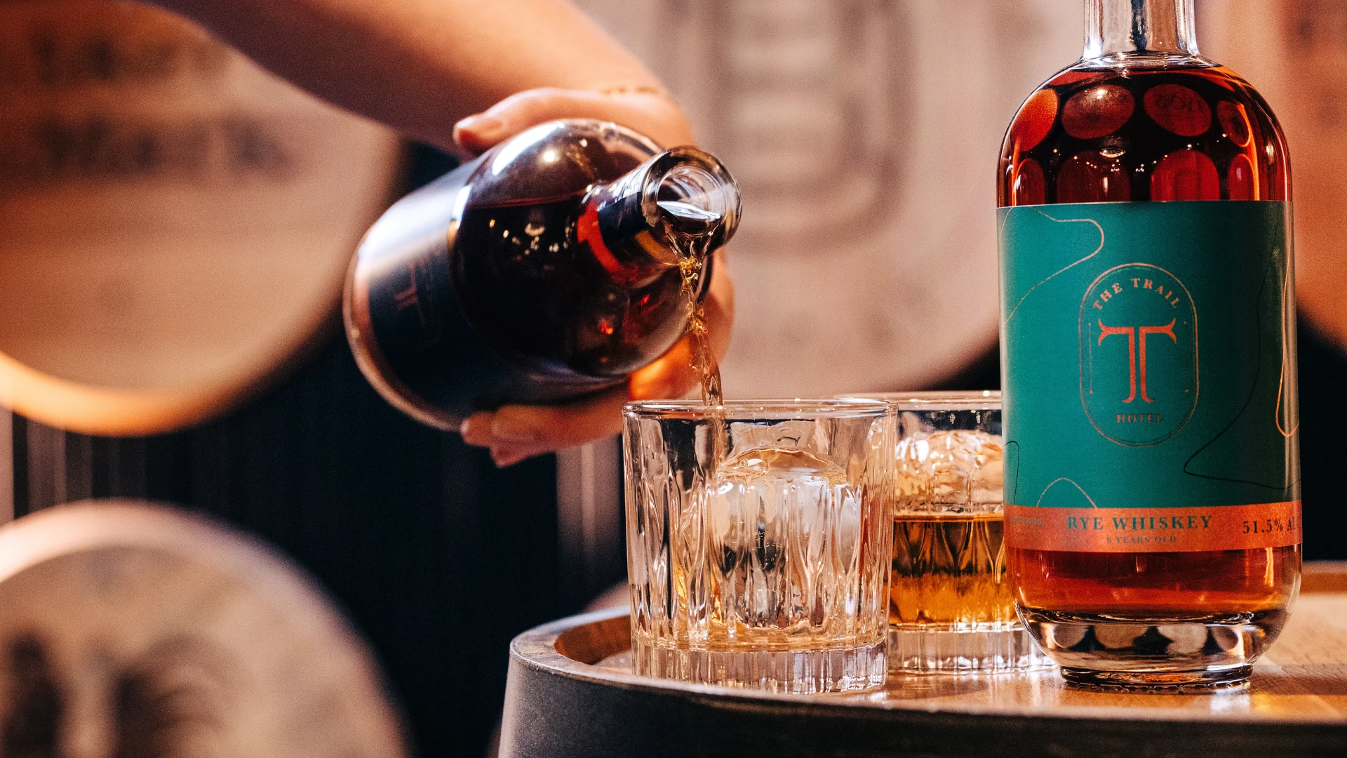 a person pouring alcohol into glasses
