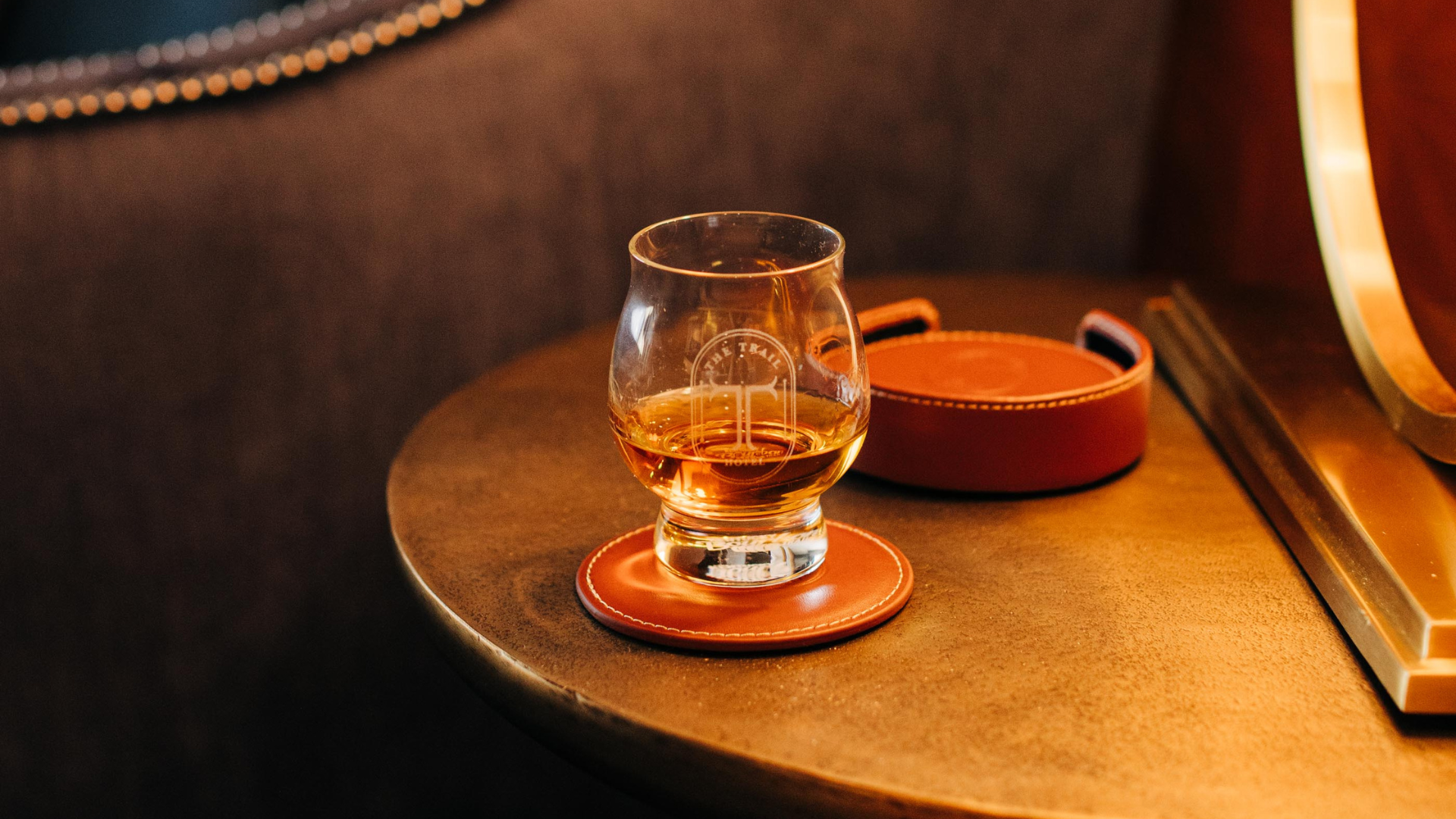 a glass of whiskey on a coaster