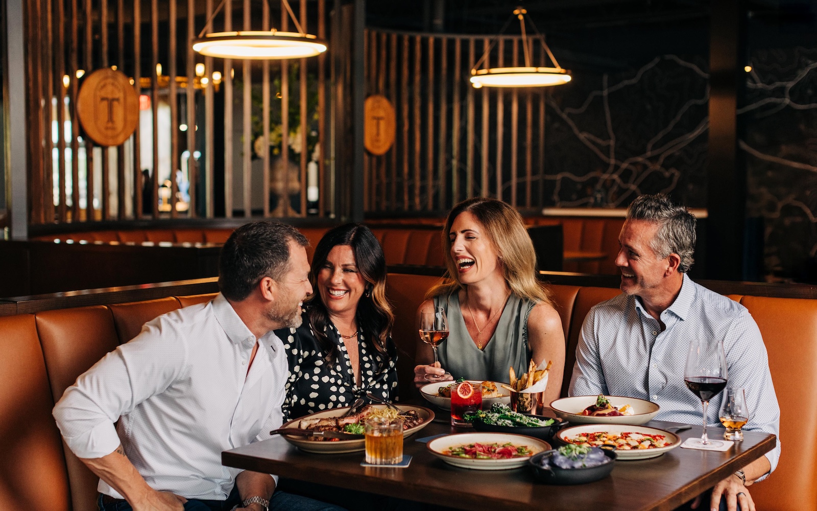 a group of people sitting at a table with food