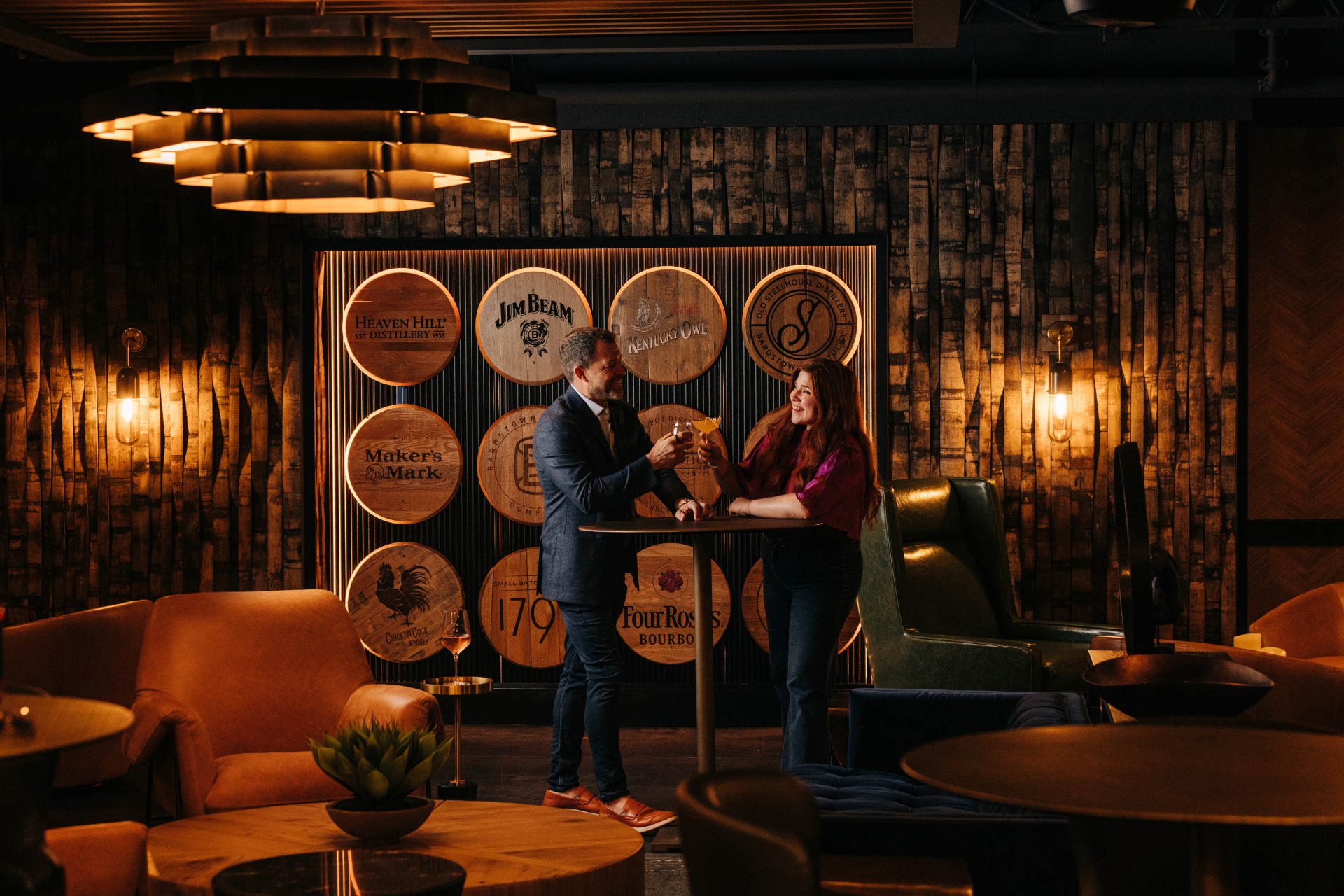 a man and woman standing at a table with drinks