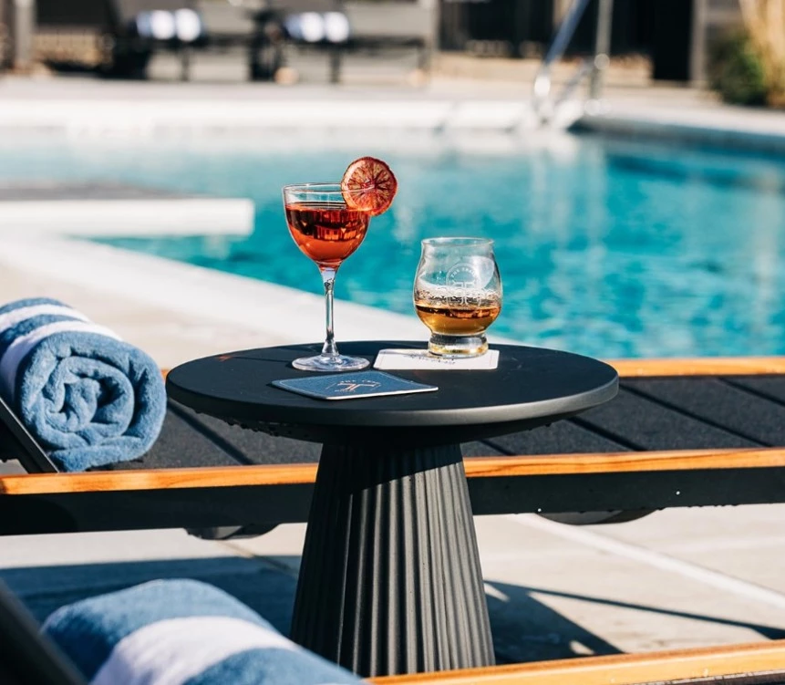 a table with drinks on it by a pool