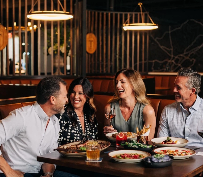 a group of people sitting at a table with food