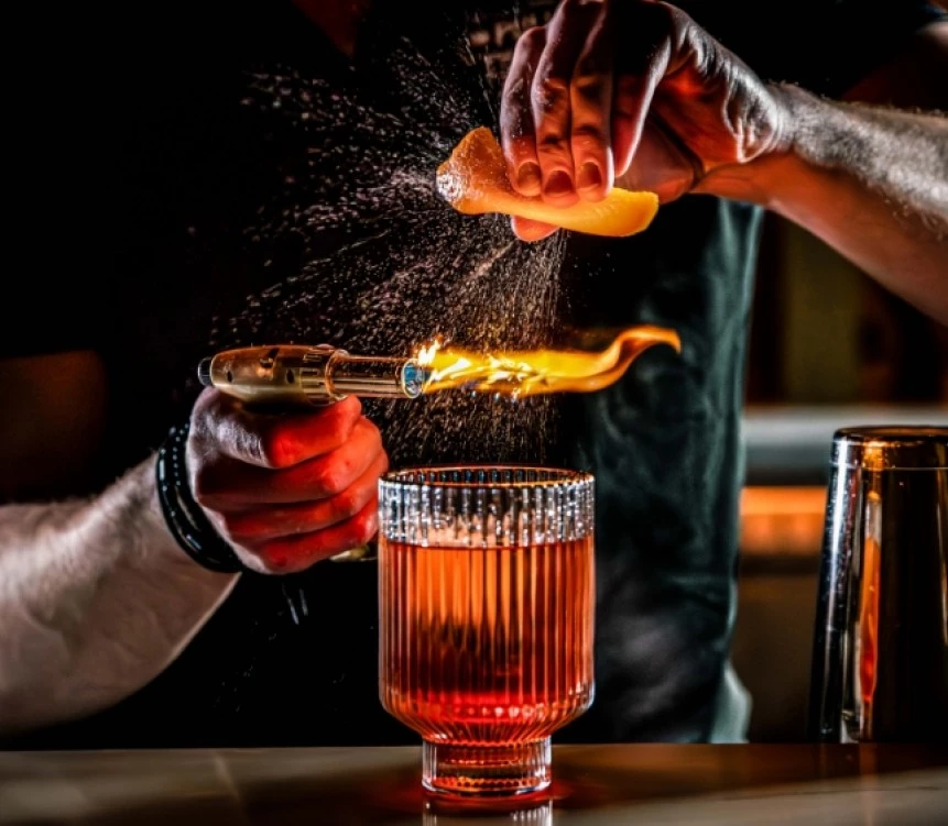 a person pouring a lemon into a glass