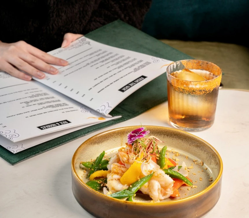a plate of food and a glass of liquid next to a book