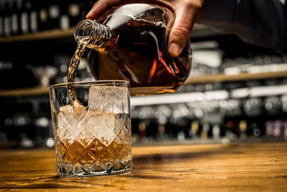 a person pouring a drink into a glass
