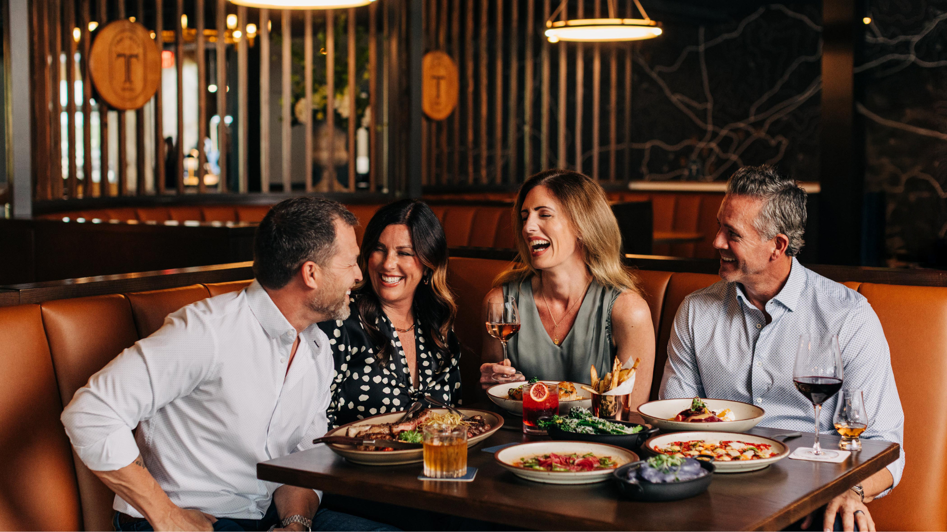 a group of people sitting at a table with food
