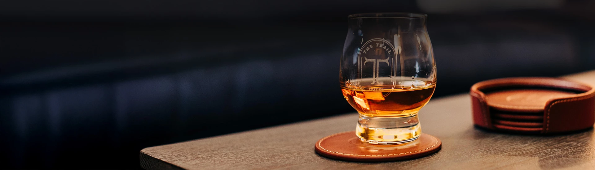 a glass of alcohol on a coaster