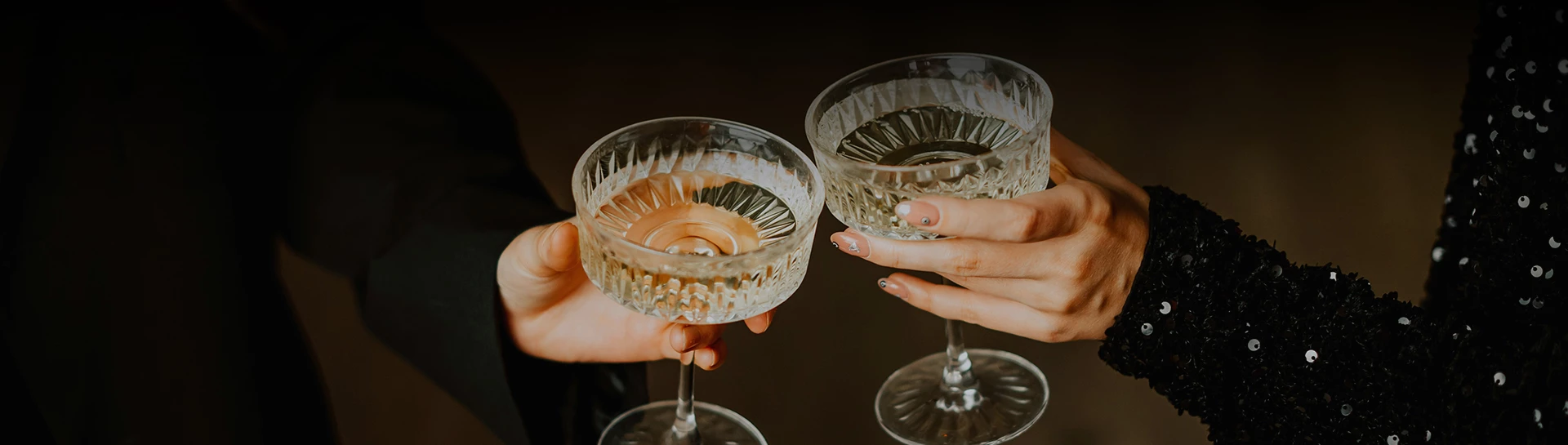 a pair of hands holding wine glasses